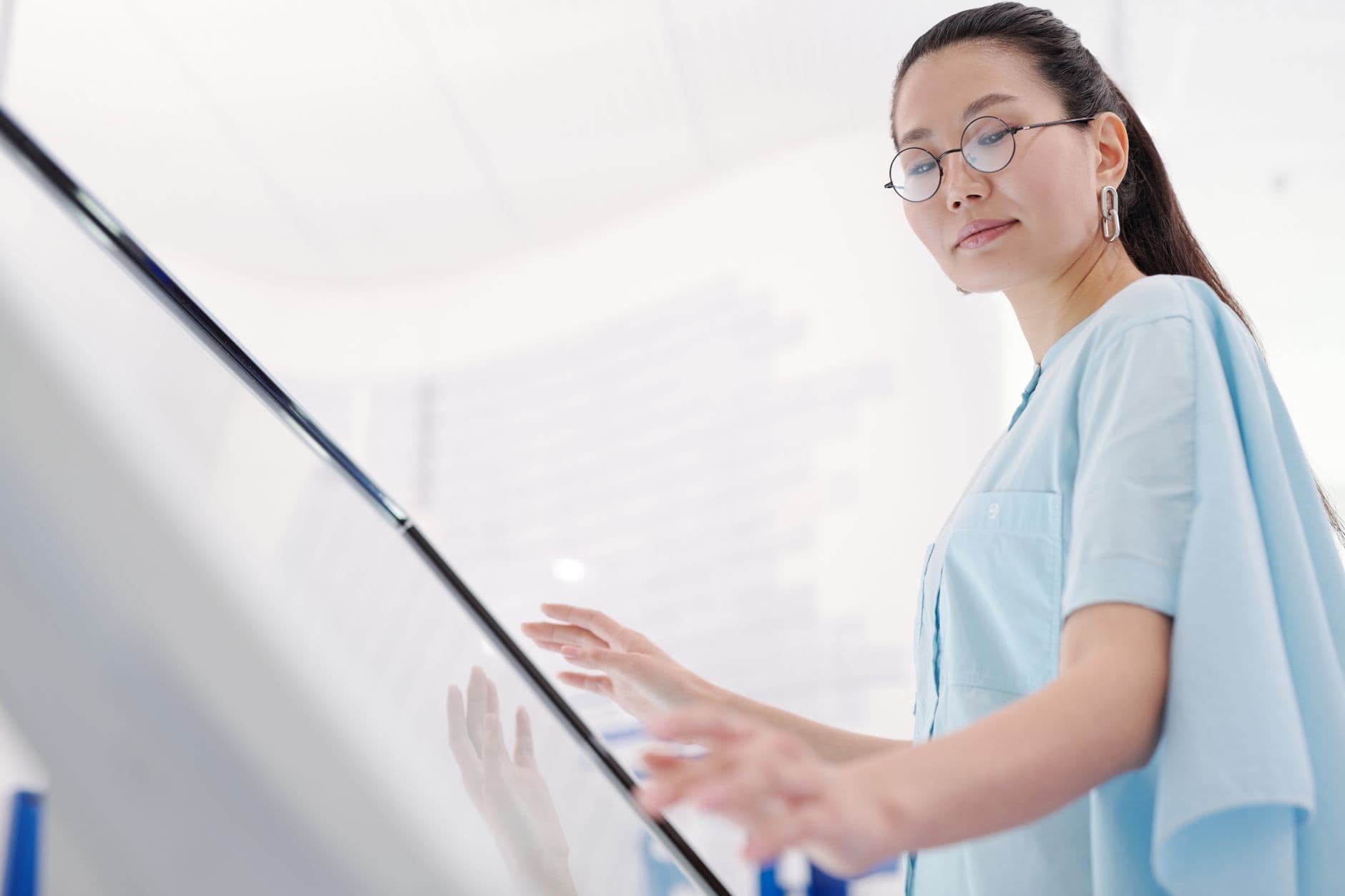 Stylish woman using a touchscreen display indoors emphasizing modernity and fashion.