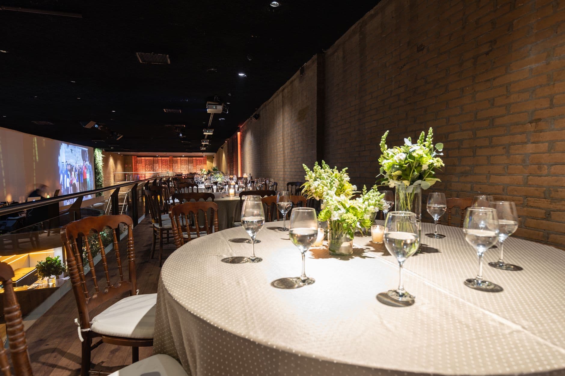 Stylish restaurant interior featuring round tables, floral arrangements, and ambient lighting for a sophisticated dining experience.