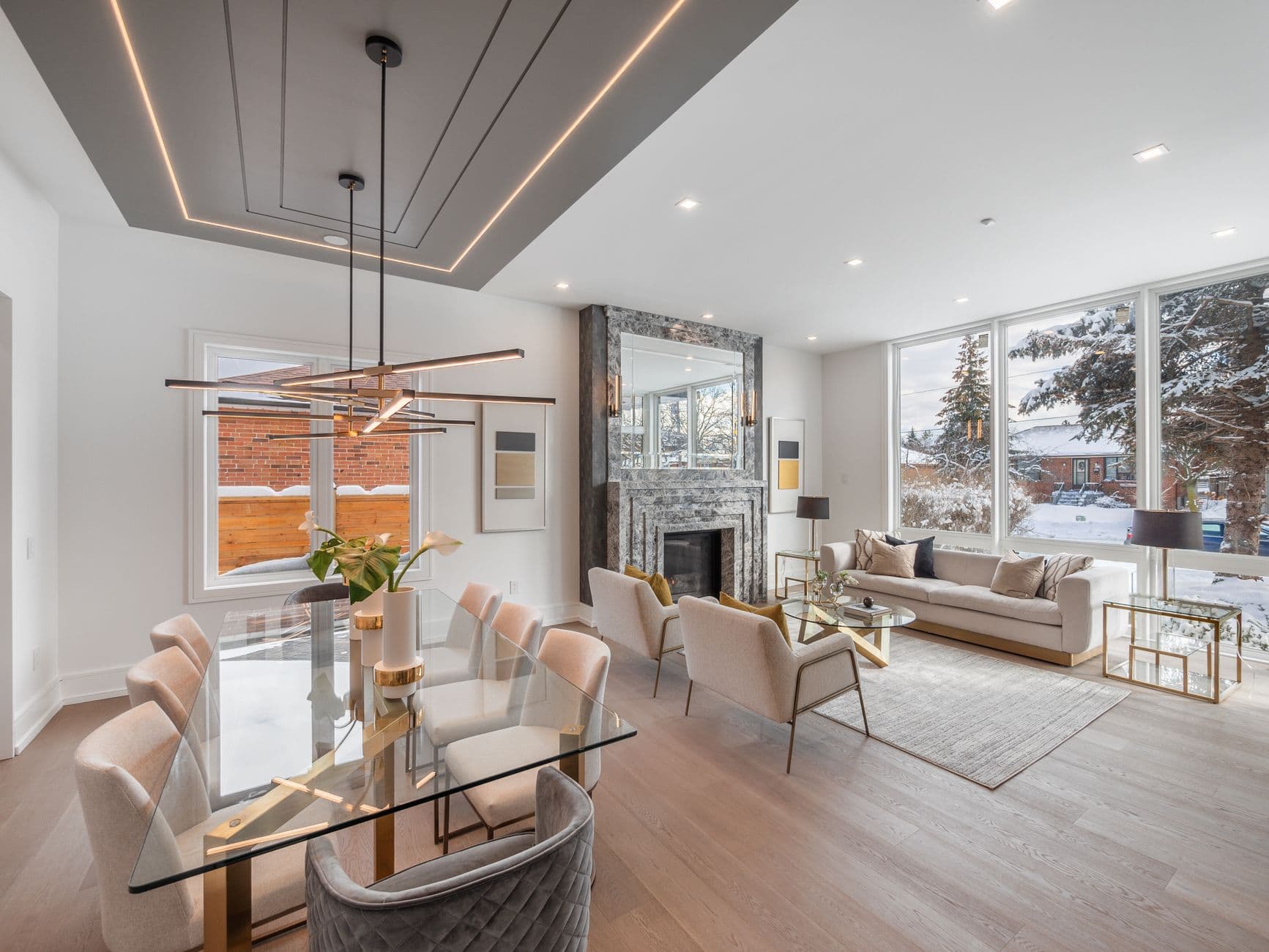 Spacious modern living room and dining area with elegant decor and a winter view in Toronto.